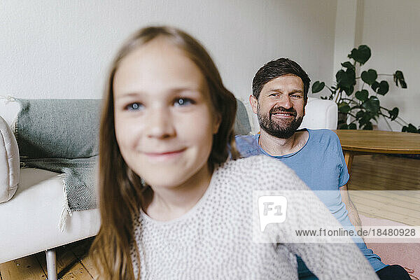 Happy man looking at daughter in living room