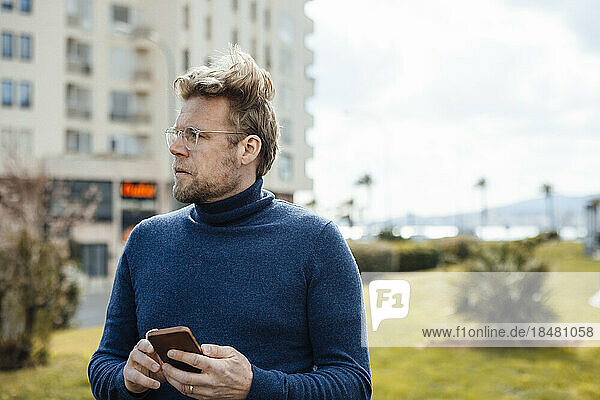 Contemplative man with mobile phone