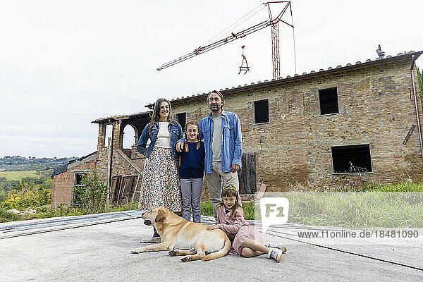 Happy family with dog in front of house