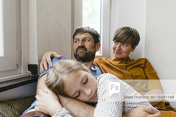 Vater und Mutter mit Tochter entspannen sich zu Hause