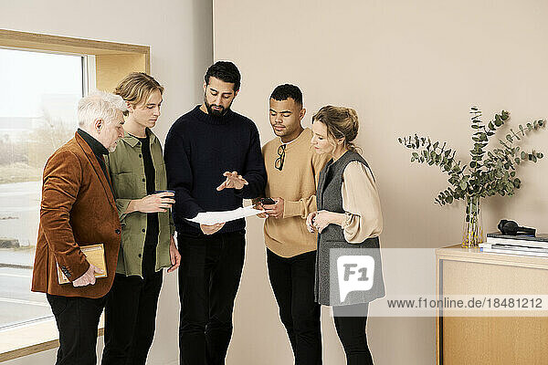 Fashion designer in meeting with colleagues standing at studio