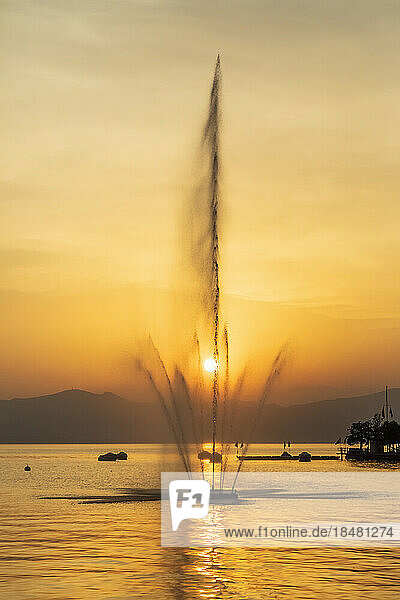 Italy  Veneto  Bardolino  Lake Garda fountain splashing against setting sun