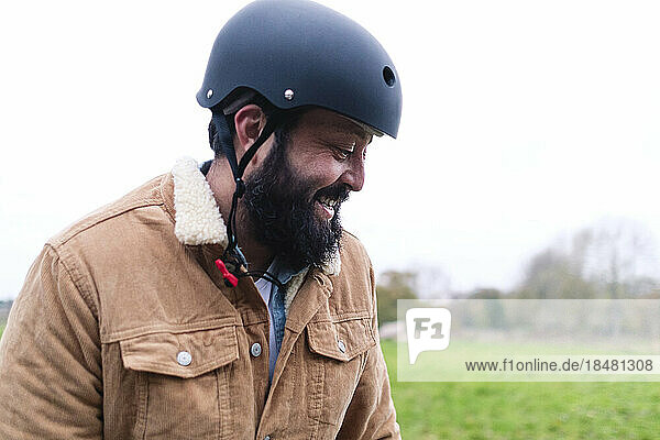 Happy man wearing helmet in nature