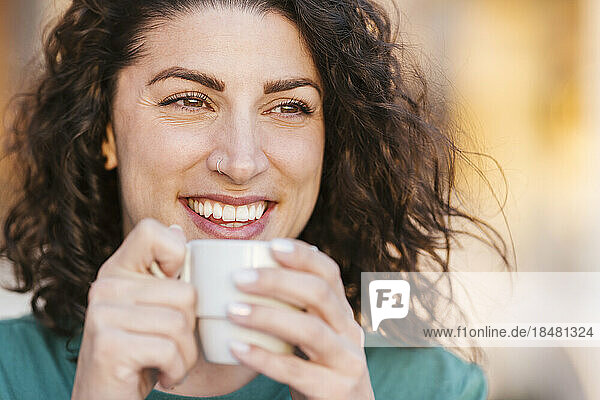 Happy woman having coffee at sunset
