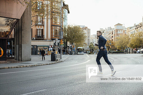 Man running on road in city