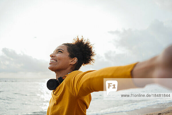 Young woman with arms outstretched at beach