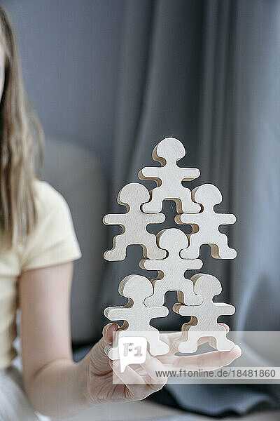 Girl holding stack of wooden toy at home