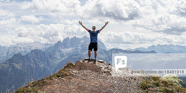 Carefree man standing with arms raised at San Pellegrino  Dolomites  Italy