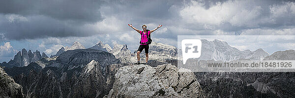 Senior woman standing with arms raised at Langkofel  Dolomites  Italy