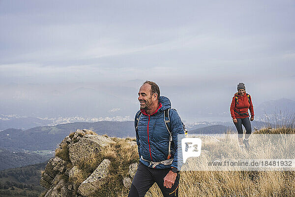 Smiling man and woman hiking on mountain