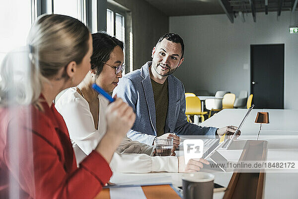 Businessman discussing with colleagues in meeting at office
