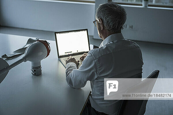 Techniker arbeitet am Laptop und sitzt am Schreibtisch im Büro