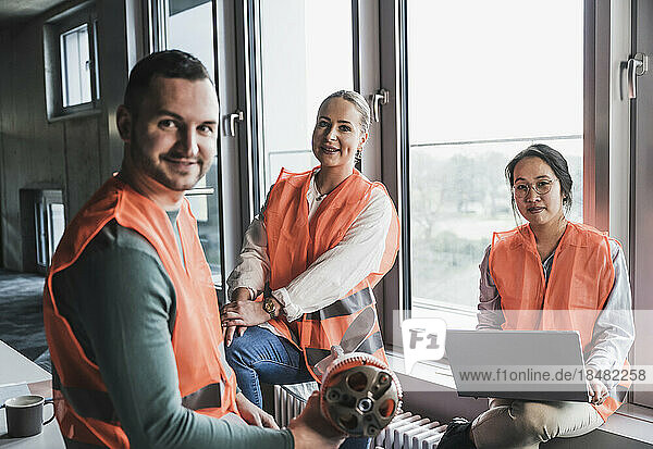 Multiracial colleagues wearing reflective clothing at office
