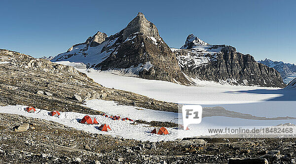 Tents on snow covered mountain under blue sky at Schweizerland Alps  Greenland