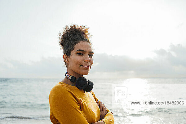 Young woman with headphones in front of sea