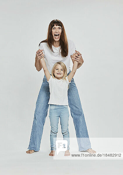 Glückliche Mutter und Tochter  die Spaß vor weißem Hintergrund haben