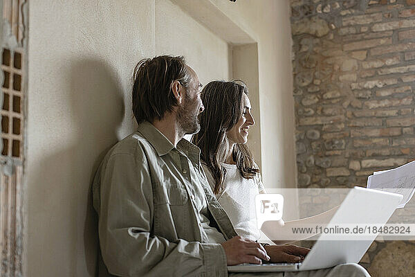 Happy couple having discussion over document at site