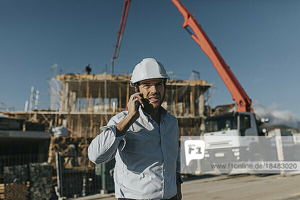 Architect talking on mobile phone at construction site