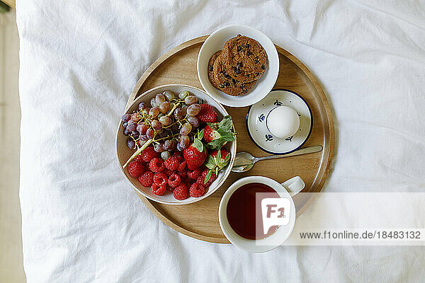 Breakfast on wooden tray in bed at home