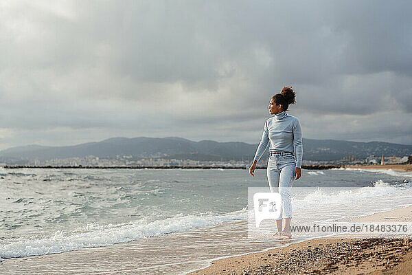 Junge Frau geht am Strand entlang
