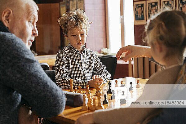 Kids playing chess with grandfather at country club