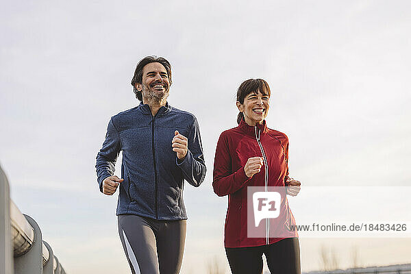 Happy mature man and woman running together
