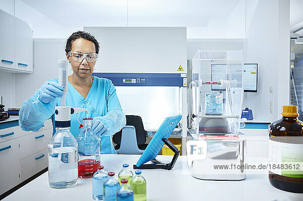 Female scientist mixing liquids in a microbiological lab