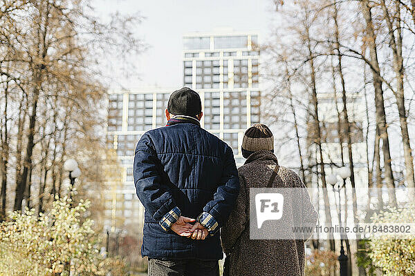 Senior man and woman strolling in autumn park