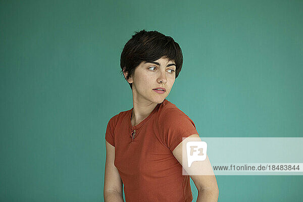 Young woman with short hair against green background