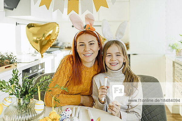 Glückliche Mutter mit Tochter  die zu Hause Ostern feiert