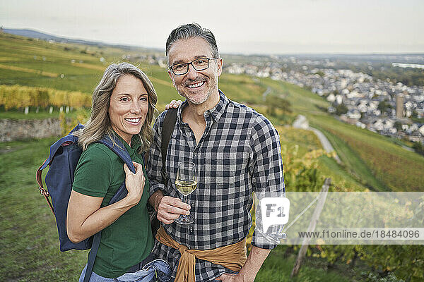 Reife Frau mit Mann hält Weinglas auf Hügel