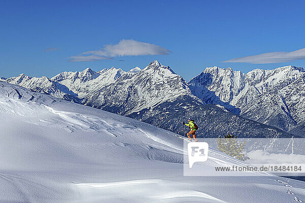 Österreich  Tirol  Skifahrerin steigt den schneebedeckten Hang in den Tuxer Alpen hinauf