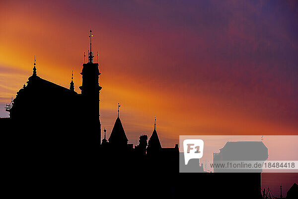 Silhouette buildings and Gdansk Crane Gate under twilight sky