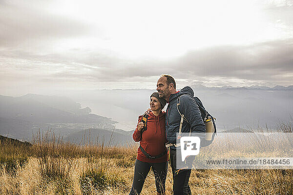 Älteres Paar mit Rucksäcken steht auf dem Berg