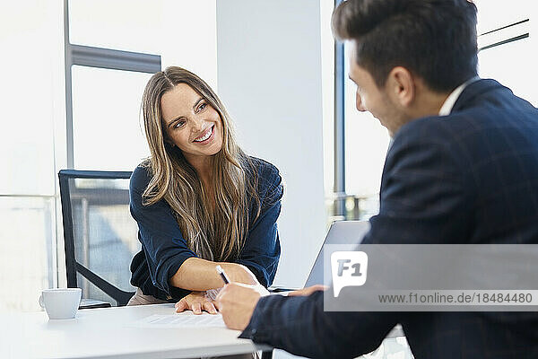 Happy businesswoman completing recruitment process with candidate at office