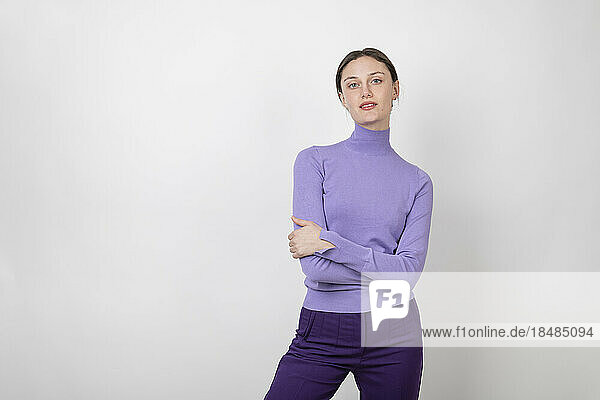 Confident woman standing with arms crossed over white background
