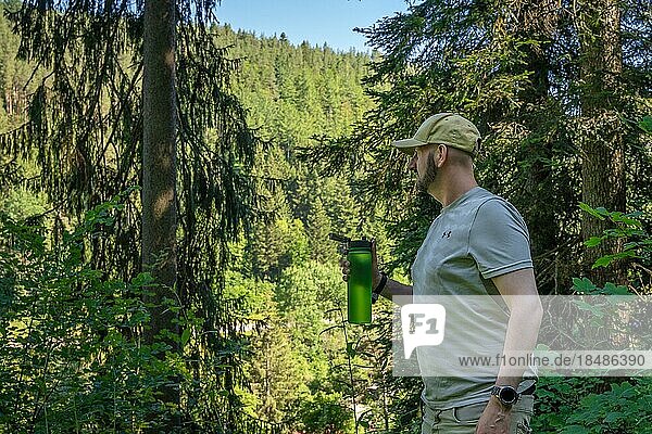 Wandersmann trinkt grüner Flasche im Wald  Bad Wildbad  Schwarzwald  Deutschland  Europa