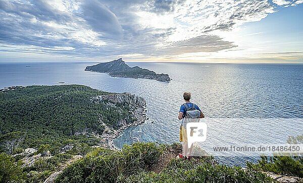 Hiker looking into the distance  view of mountains and coast with sea  in the evening light  hiking to La Trapa from Sant Elm  in the back island Sa Dragonera  Serra de Tramuntana  Majorca  Spain  Europe