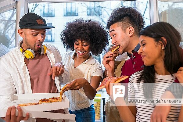 Portrait of a group of friends eating pizza on the terrace at home  lunch or dinner  lifestyle  distributing a delicious pizza from the box