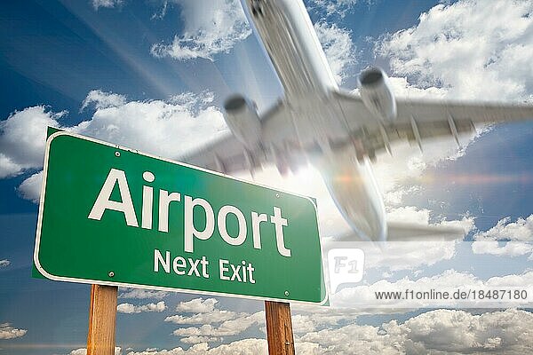 Flughafen nächste Ausfahrt grünes Straßenschild und landendes Flugzeug oben
