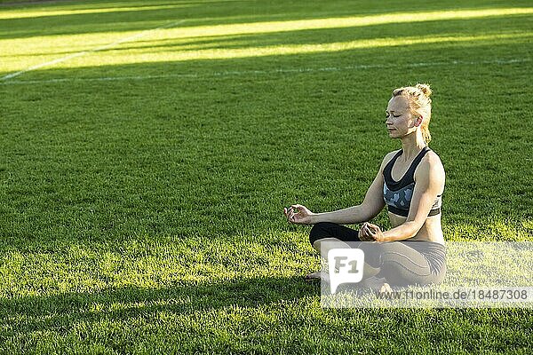 Frau (38) macht Yoga auf einer Wiese im Park  Kiel  Schleswig-Holstein  Deutschland  Europa