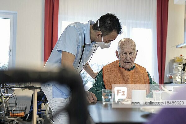 Pfleger spricht mit einem Mann im Pflegeheim  Heidelberg  Deutschland  Europa