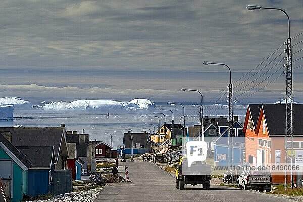 Eisberg und bunte Häuser in der Stadt Ilulissat  Jakobshavn  Diskobucht Grönland