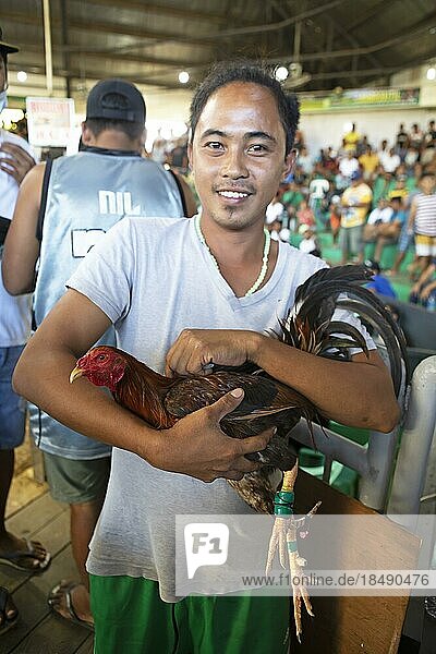 Filipino man with a fighting cock  cockfighting arena  Barangay Manoc-Manoc  Boracay Island  Visayas Island Group  Philippines  Asia