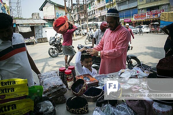 Ein indischer muslimischer Vater kauft eine Mütze für seinen Sohn  bevor er das zweite Freitagsgebet im heiligen Monat Ramadan in einer Moschee in Guwahati  Indien am 31. März 2023 verrichtet