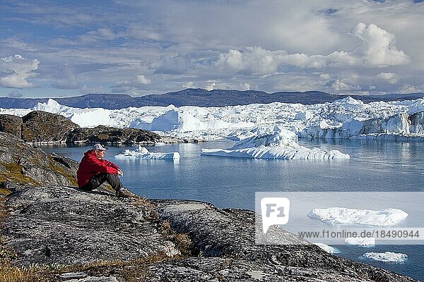 Tourist looking at Kangia Icefjord  Disko-Bay  UNESCO-World Heritage Site  West-Greenland  Greenland  North America
