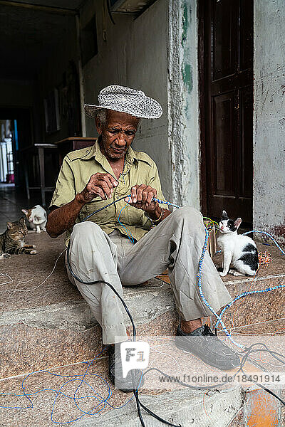 Electrician wiring himself in knots with his cats  Santa Clara  Cuba  West Indies  Caribbean  Central America
