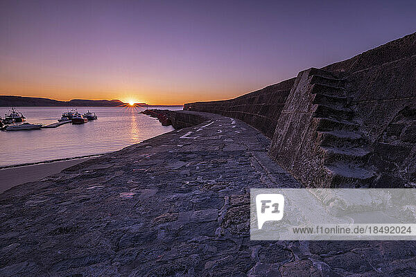 Sonnenaufgang an der als The Cobb bekannten Hafenmauer in Lyme Regis  Dorset  England  Vereinigtes Königreich  Europa