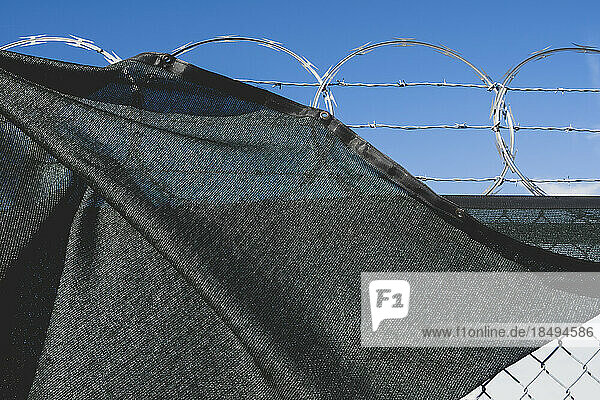 A barbed wire fence and draped fabric.