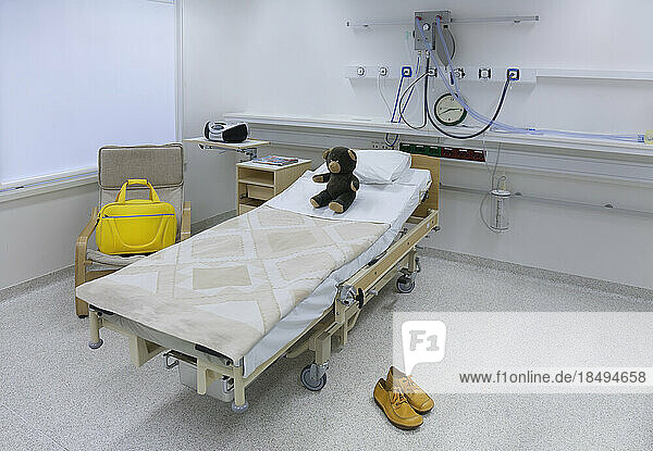 The intensive care or high dependency unit of a children's ward in hospital  a family room bed  yellow bag and shoes. Tartu University hospital.